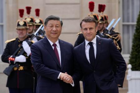 ６日、フランス・パリで握手を交わすマクロン大統領（右）と中国の習近平国家主席（ＡＰ＝共同）
