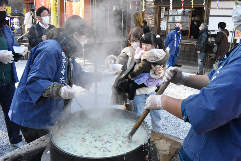 大釜で炊かれた七草粥を受け取る参拝客ら＝7日午前11時ごろ、長瀞町長瀞の不動寺
