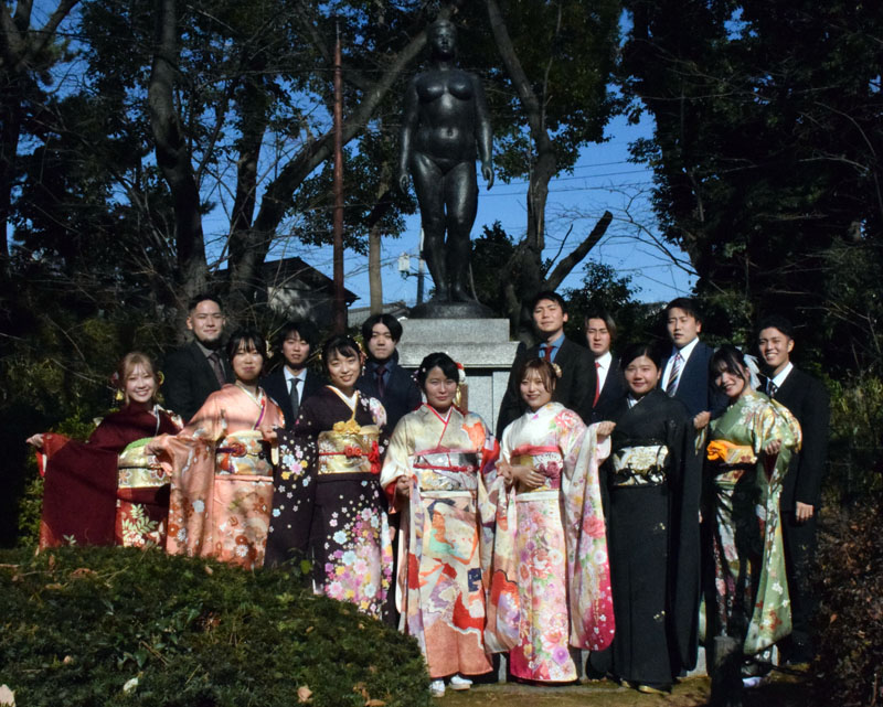 成年式発祥の地記念像の前で実行委員会が記念撮影＝9日、蕨市