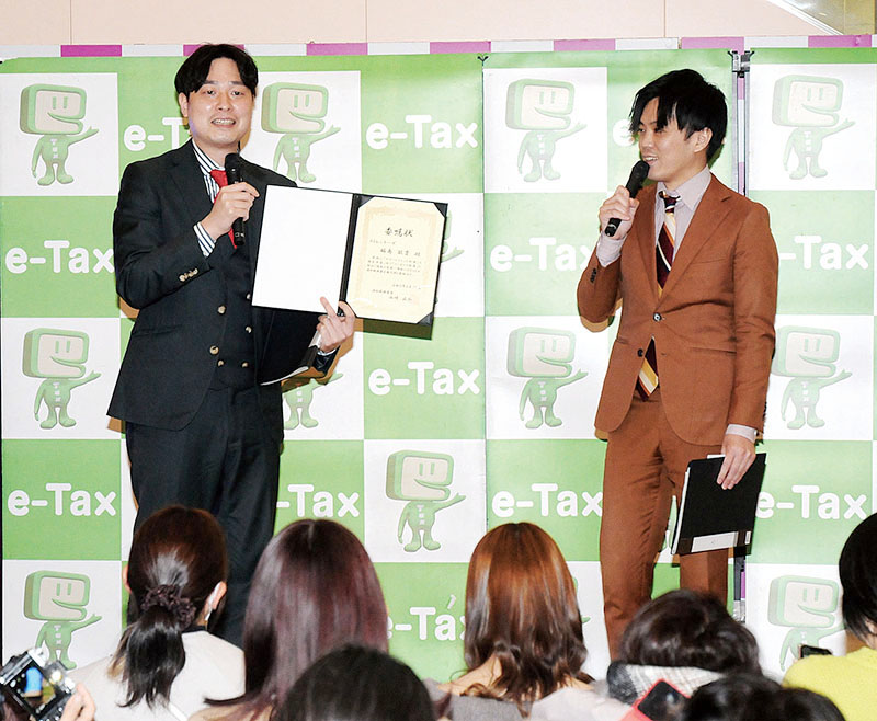 スマホで確定申告をアピールするストレッチーズの（左から）福島さんと高木さん＝さいたま市中央区のイオンモール与野