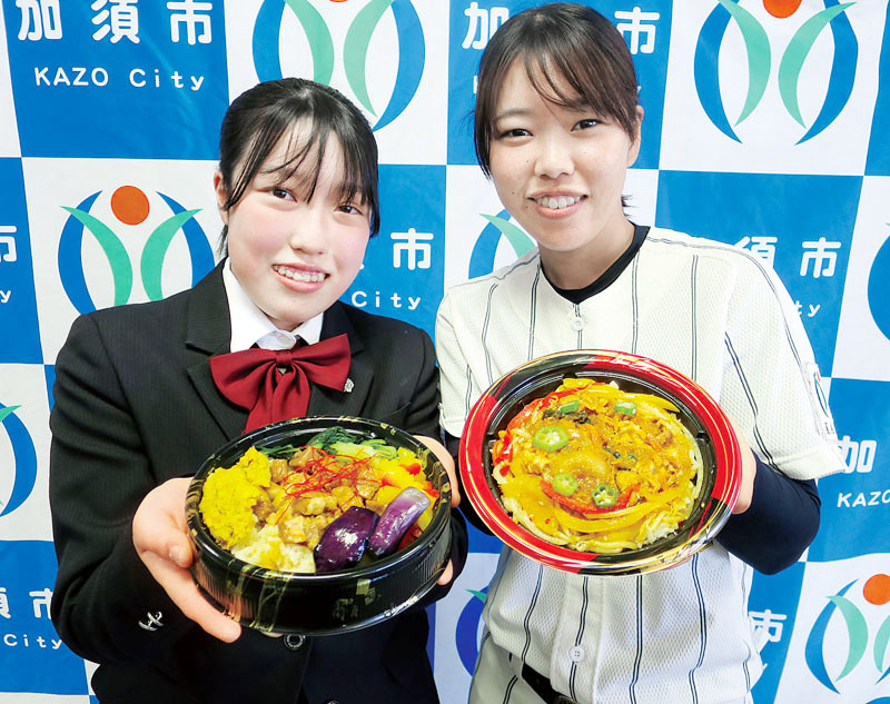 「アスメシ丼クイーン」を持つ柴正枝さん（左）と、「アスメシ丼キング」を持つ井上愛海さん＝8日、加須市の市民プラザかぞ