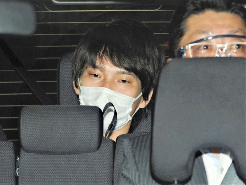 逮捕時に熊谷署へ入る冨田賢容疑者（左）＝2021年10月21日午後8時17分、熊谷署