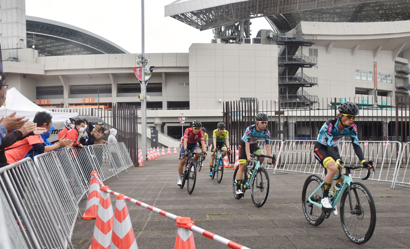 レースで滑走する選手と、声援を送る観客たち＝20日正午ごろ、埼玉県さいたま市緑区の埼玉スタジアム2002