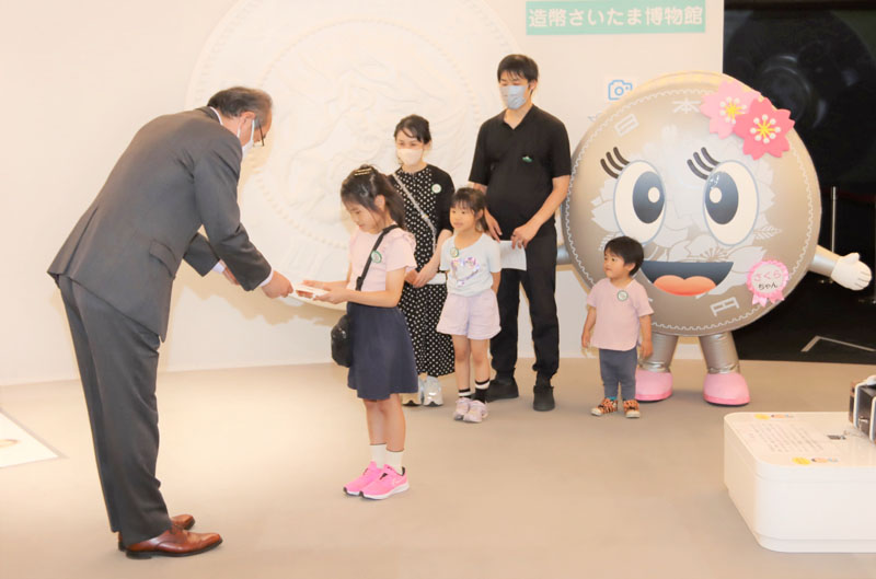 記念品を贈呈される来館者30万人目の家族（右）（提供写真）