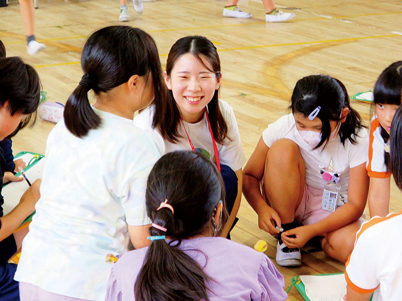4年生たちに「世界に目を向けてほしい」と話すユニクロの鯨岡英利子さん（中央）＝20日、加須市立礼羽小学校