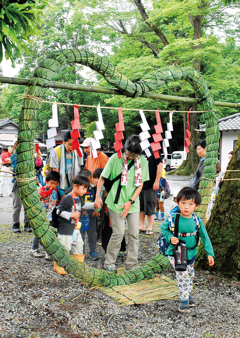 ハート型の茅の輪をくぐる子どもたち＝30日午後3時半ごろ、埼玉県秩父市下吉田の椋神社内