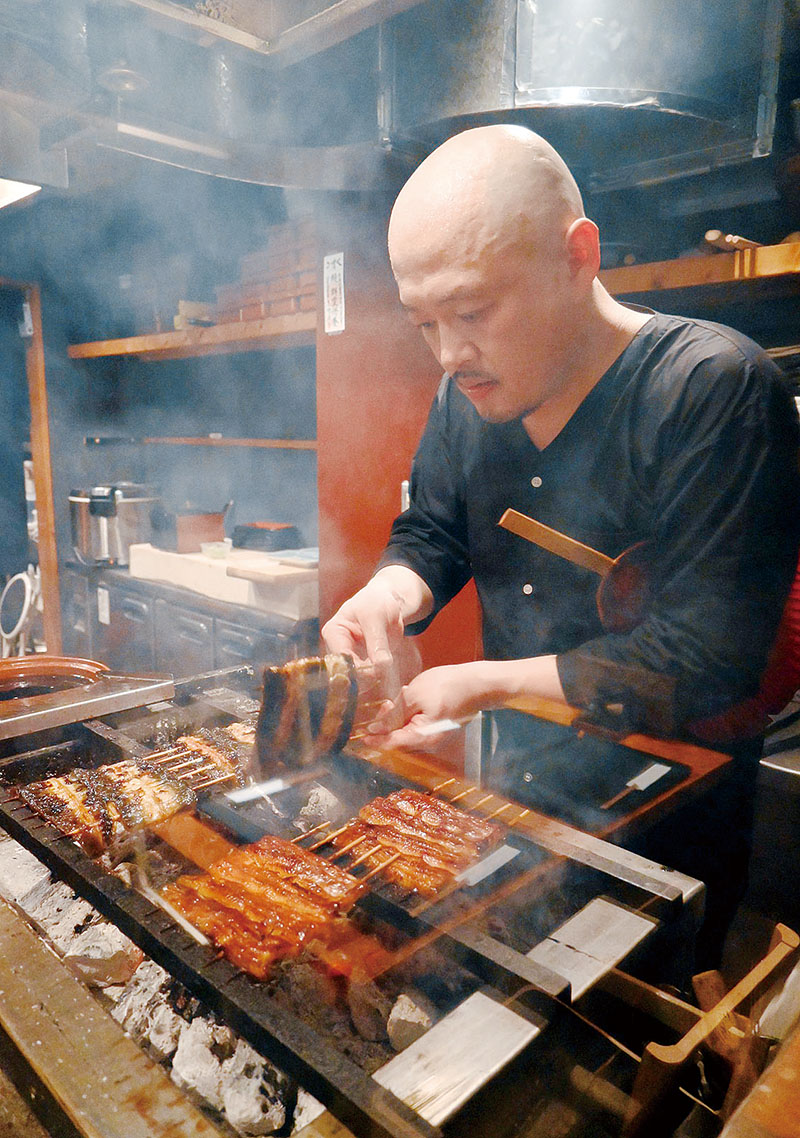 紀州備長炭を操りながら丁寧にかば焼きを仕上げていく延原さん