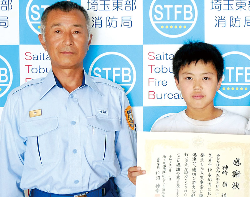 感謝状を受け取る神崎嶺さん（右）＝久喜消防署提供