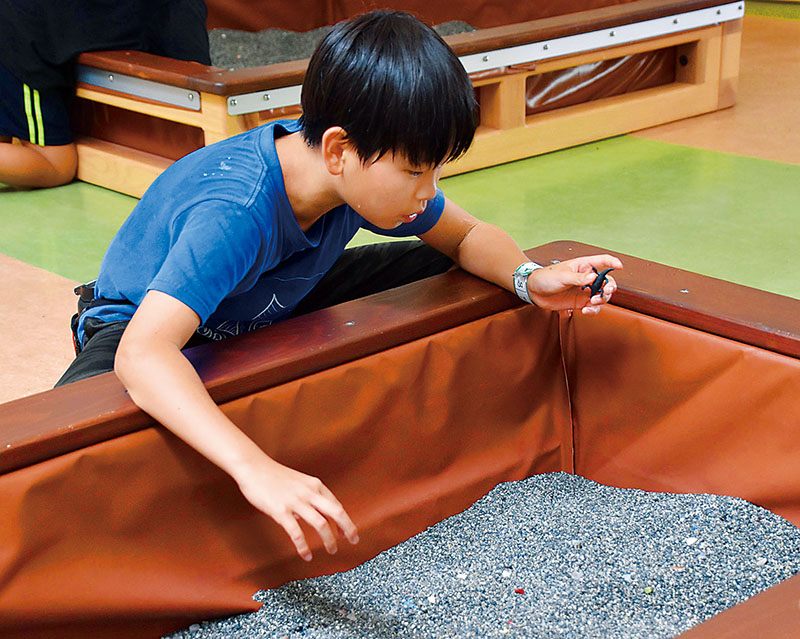 宝探しイベントで見つけた恐竜のフィギュアを手にする男児＝埼玉県加須市志多見のむさしの村