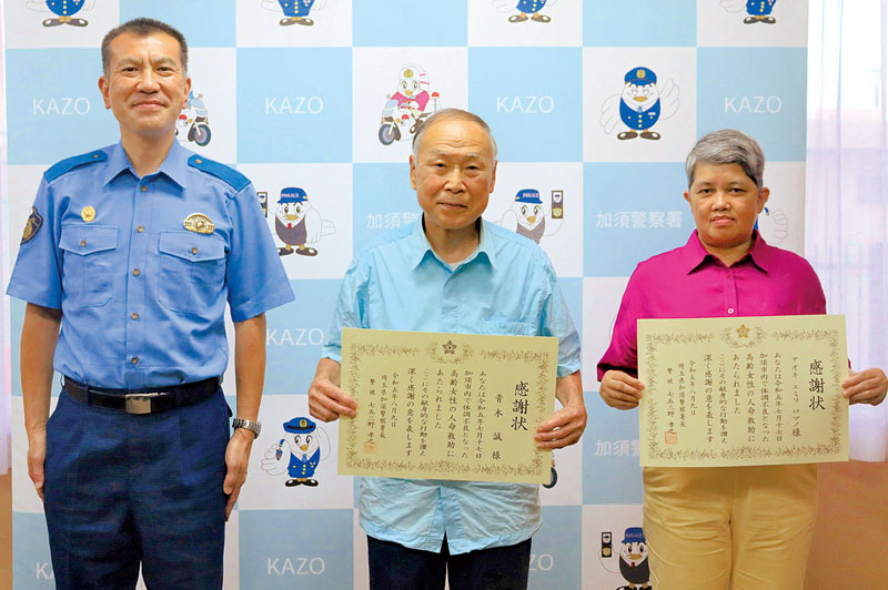 七五三野孝之署長（左）から感謝状を受け取った青木誠さん（中央）とアオキ・エミリ・ロマノさん＝9日、埼玉県警加須署