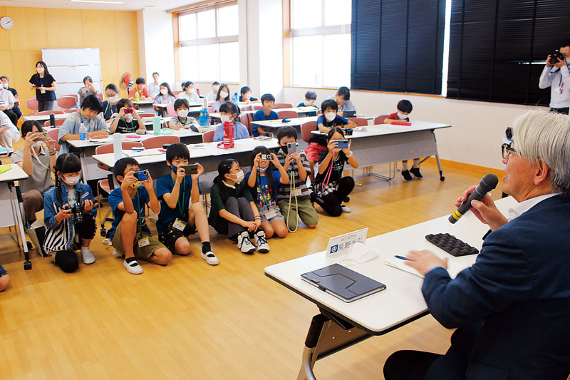 写真撮影に挑戦する児童らと質問に答える星野光弘市長（手前）＝8日午後、埼玉県富士見市市民総合体育館