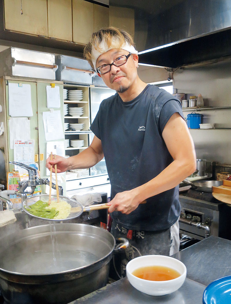 厨房で腕をふるう2代目店主の相澤貴幸さん＝羽生市中央の麺飯飲処「華楽」