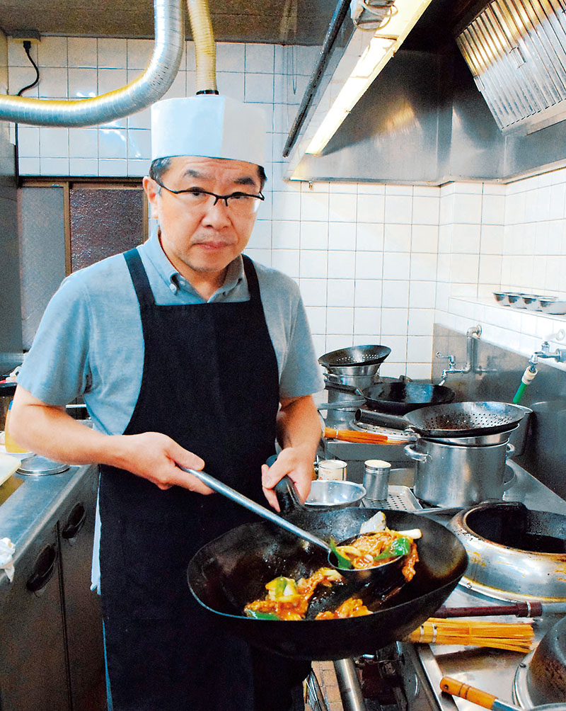 厨房に立つ店主の本柳靖博さん＝川口駅近く、ふじの市商店街の「中国料理・大晃飯店」