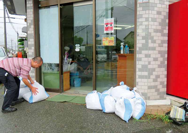 土のうを確認する障害者就労支援施設のスタッフ＝8日午前、埼玉県越谷市弥栄町