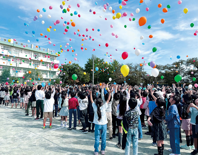 創立150周年記念のバルーンリリースを行う児童ら＝14日午前、埼玉県さいたま市緑区の三室小学校