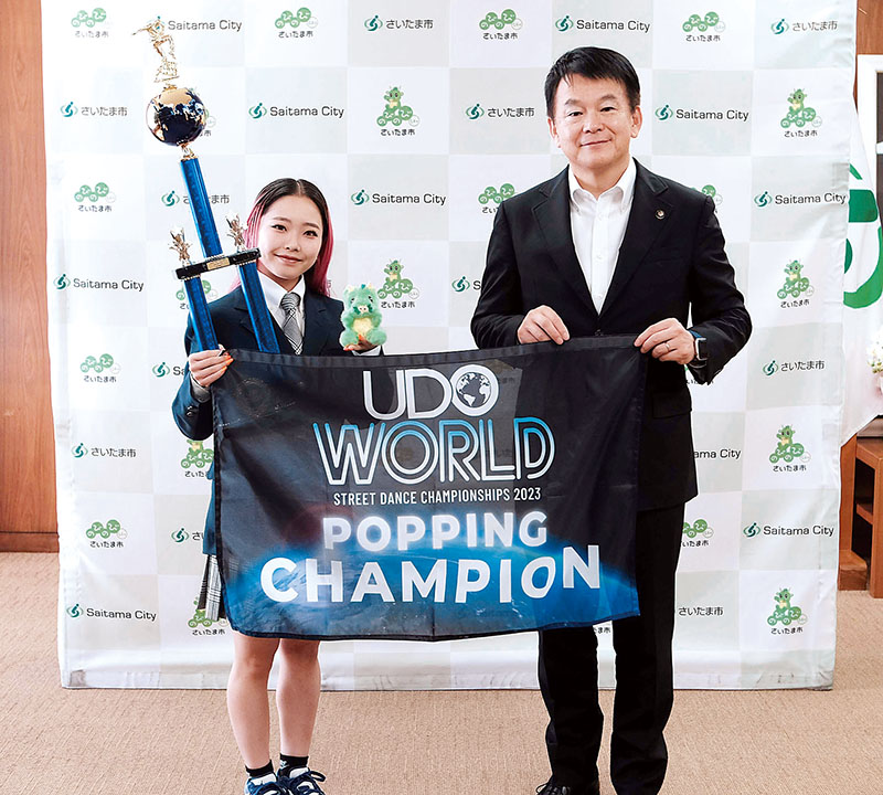 世界大会の優勝トロフィーと優勝フラッグを持つ森田羽楽さん（左）と清水勇人市長＝3日午後、さいたま市役所