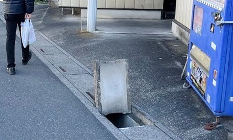 側溝のふたが開けられた道路（春日部市提供）