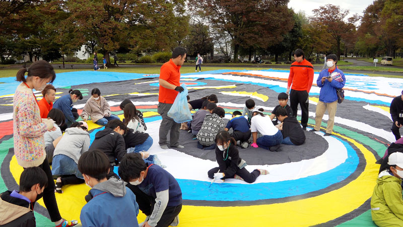 ジャンボこいのぼりの目の辺りを色付けで補修する子どもたち＝埼玉県加須市水深の加須はなさき公園芝生広場
