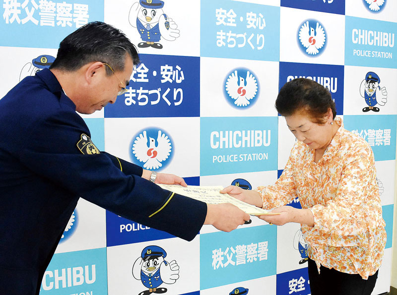 小谷和樹署長（左）から感謝状を受け取るセブンイレブン秩父影森店若林時子オーナー＝秩父署