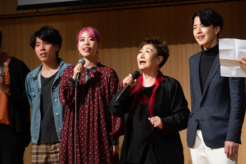加藤登紀子さん（中央右）と合唱する山本昌子さん（同左）ら映画出演者＝11日、東京・六本木（ACHAプロジェクト提供）