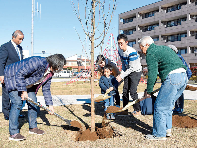 記念植樹を行う斉藤芳久市長（左）とワークショップの参加者たち＝2日、鶴ケ島市藤金のわかばハンカチノキ公園