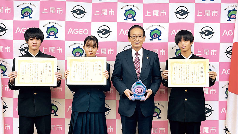 畠山稔上尾市長から最優秀賞、優秀賞、上尾キウイフルーツ研究会賞を受賞し賞状と副賞を手渡された3人の中学生（市提供）