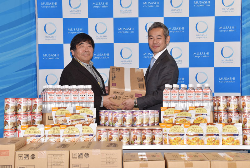 食料を寄贈した武蔵コーポレーションの太田大作専務取締役（右）とフードバンク埼玉の永田信雄理事＝25日午後、埼玉県さいたま市大宮区の武蔵コーポレーション本社