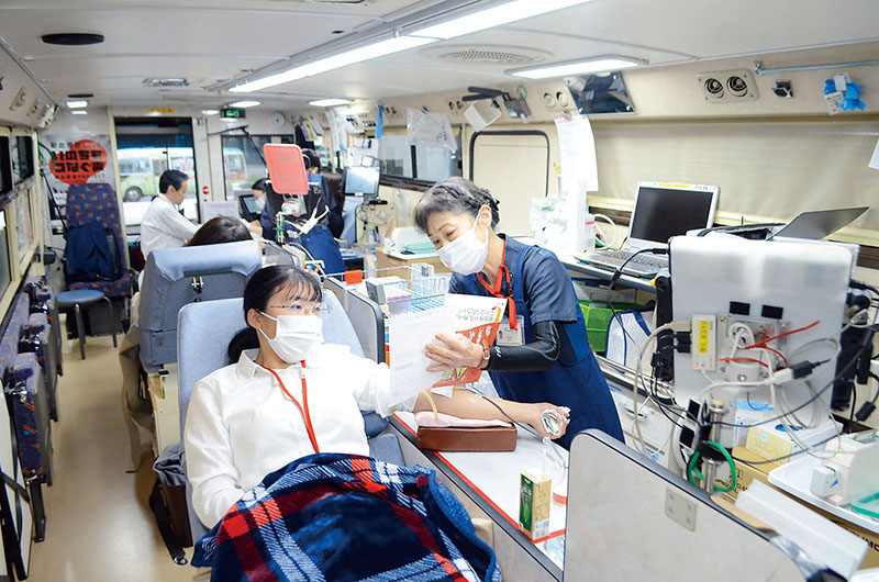 献血バス車内で献血を行う協力者ら