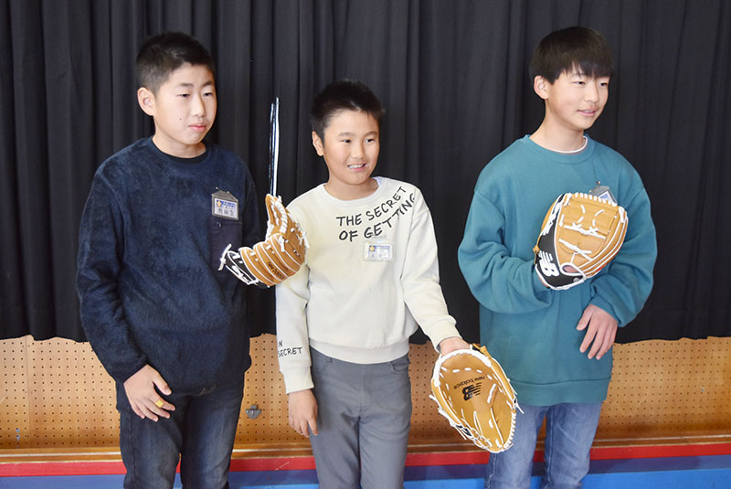大谷翔平選手から寄贈されたグラブを手にして喜ぶ児童たち＝16日午前8時半ごろ、熊谷市立太田小学校