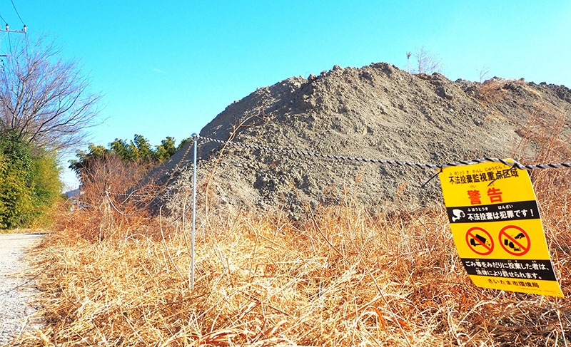 土砂が堆積している現場の一部。不法投棄を啓発する案内が掲示されている＝10日午前、さいたま市岩槻区浮谷