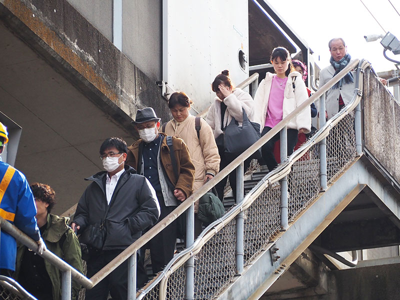 新幹線の路線から地上へ避難する乗客ら＝23日午後1時ごろ、さいたま市中央区