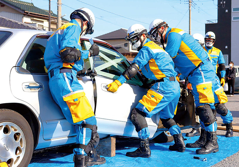 車内にいる負傷者役を救助救出しようとする警察官ら＝埼玉県越谷市東越谷のコモディイイダ第二駐車場