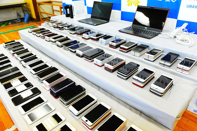 県警が押収した大量のスマートフォンなど＝25日、浦和署