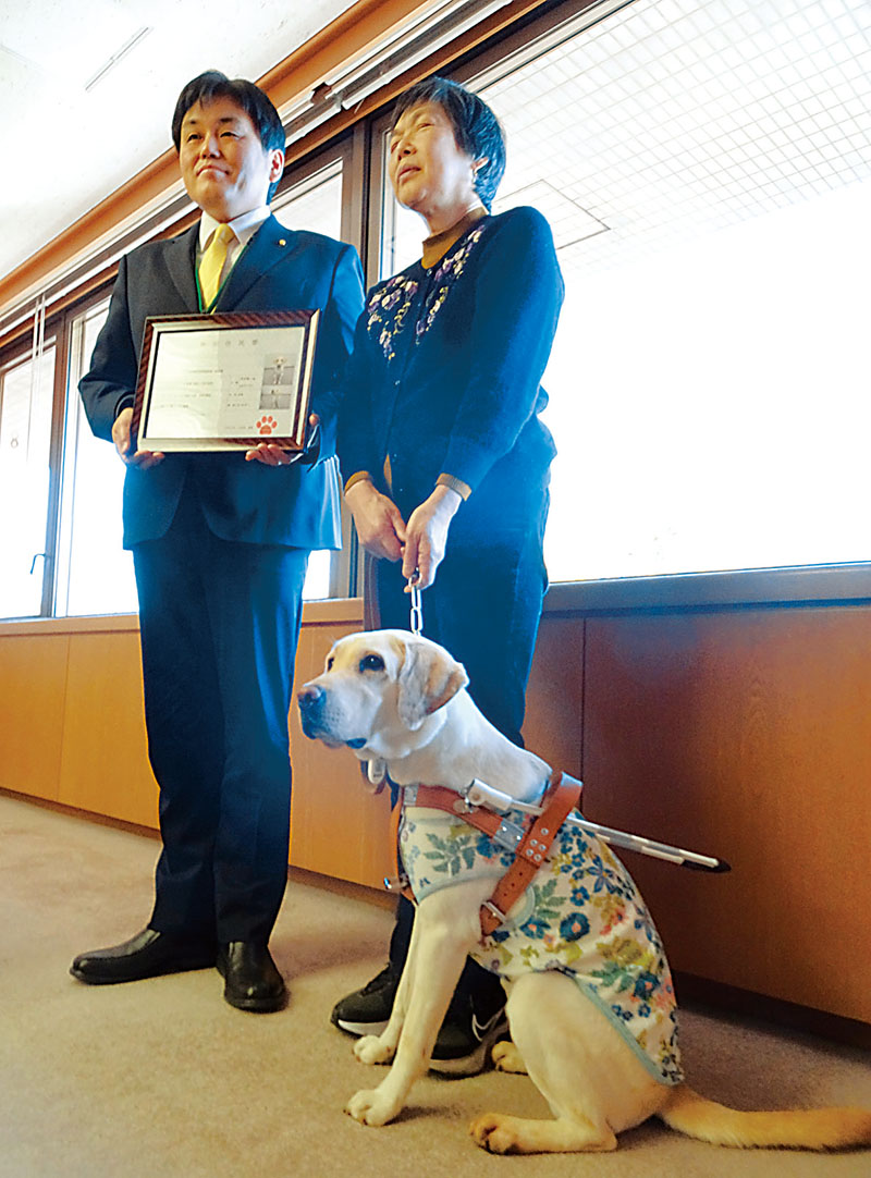 特別住民票を交付された盲導犬と矢吹美智子さん（右）、小野塚勝俊市長＝所沢市役所
