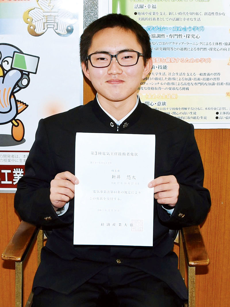 資格の免状を手に笑顔の新井悠太さん＝川越市西小仙波町の県立川越工業高校