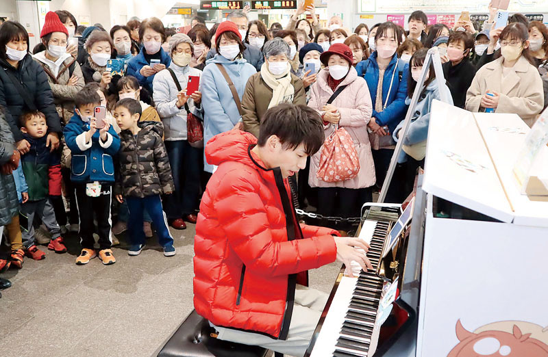 ストリートピアノを弾く細貝柊さん＝1日、JR上尾駅改札前自由通路