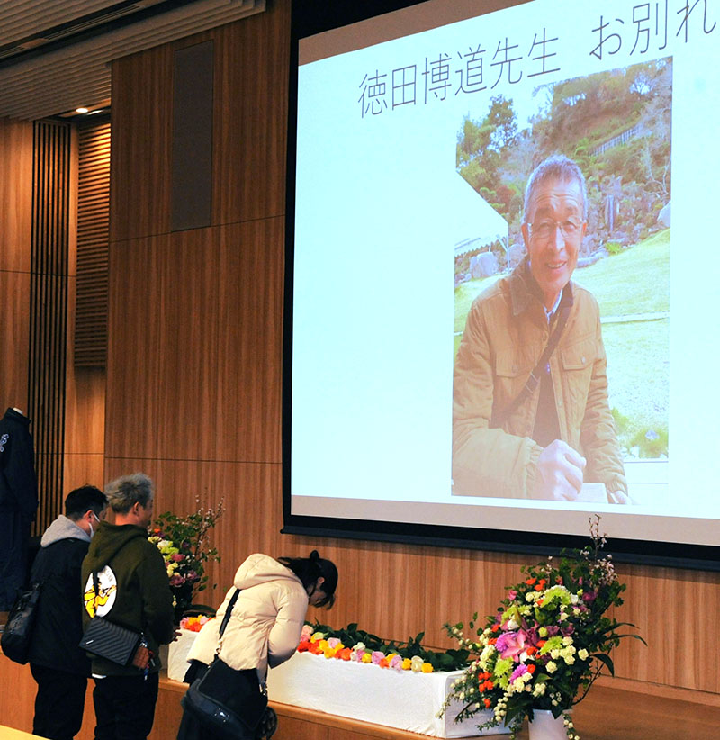 優しくほほ笑む徳田博道さんの写真に献花する参会者＝11日午後、さいたま市内