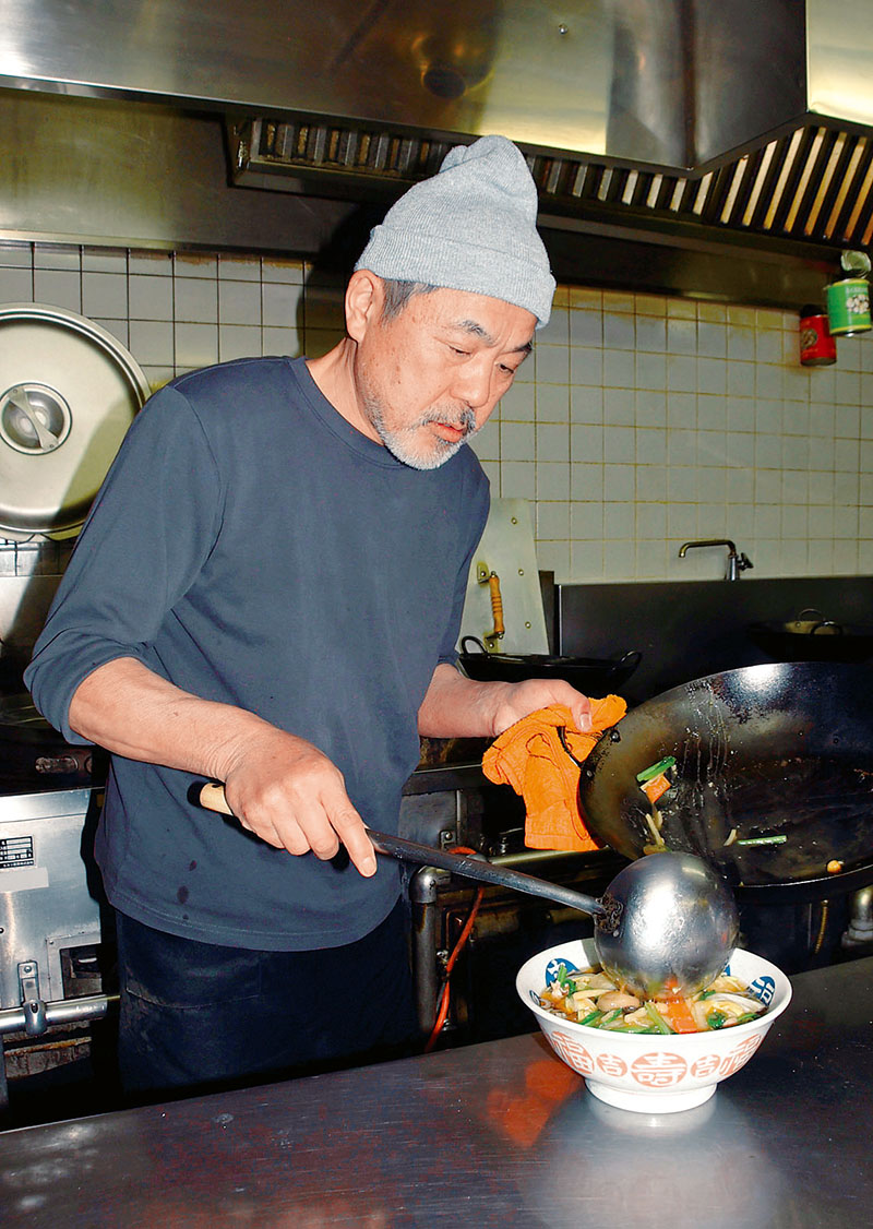 調理場で鍋を振る店主の岡部晃義さん＝坂戸市日の出町の「中華だいにんぐ福禄寿らいか」