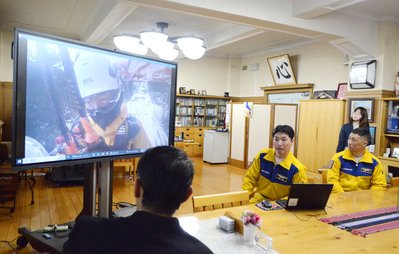 大野元裕知事（左）に活動内容を報告する埼玉県防災航空隊員ら＝19日、県庁