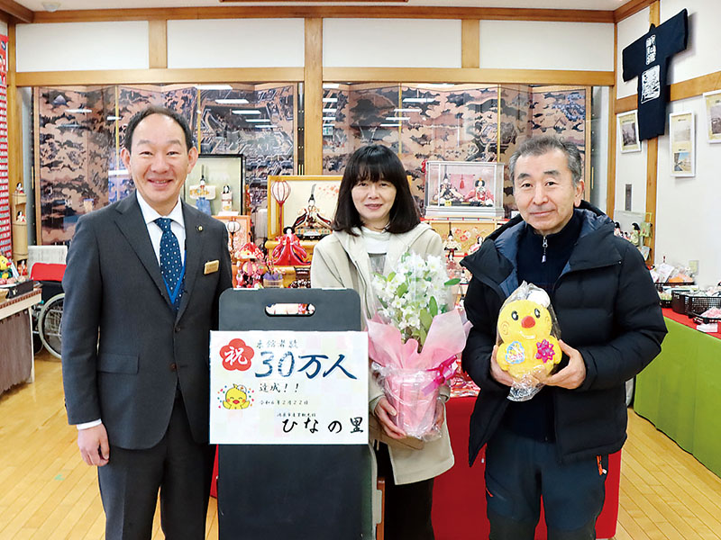 来場者30万人目の奥田勝彦さん、尚美さん夫妻に並木正年市長（左）から記念品が贈られた＝22日午前、埼玉県鴻巣市人形の「ひなの里」