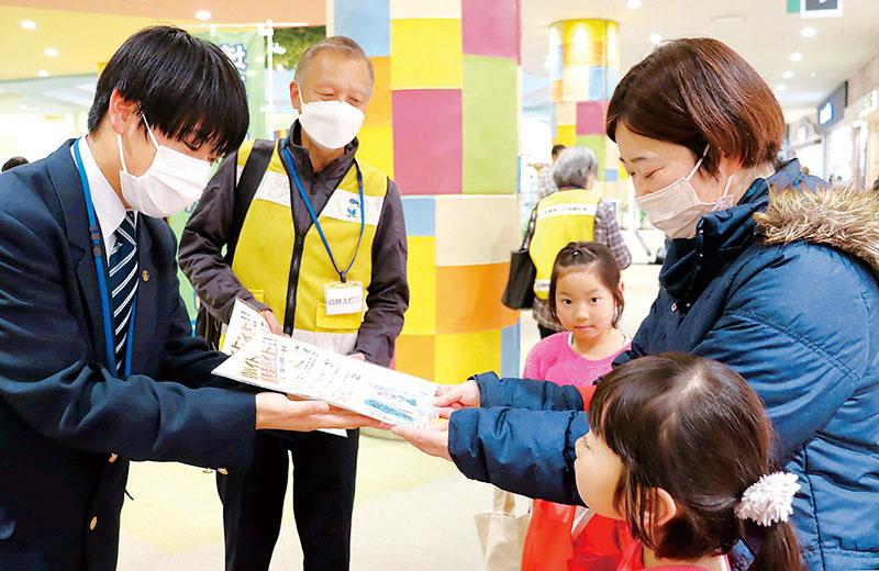 啓発品を配りながら闇バイトの危険性を呼びかける県立富士見高校の上田愛斗さんと東入間地区少年非行防止ボランティア連絡協議会の鈴木浩会長＝ららぽーと富士見