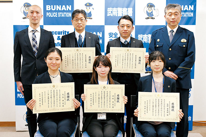 （前列右から）青木信用金庫江戸袋支店の矢作香央理さん、同鳩ケ谷支店の田村奈菜さん、瓜生華菜さん（後列右から）門井幸夫武南署長、江戸袋支店の仲田真一係長、鳩ケ谷支店の岩崎二郎支店長＝武南署