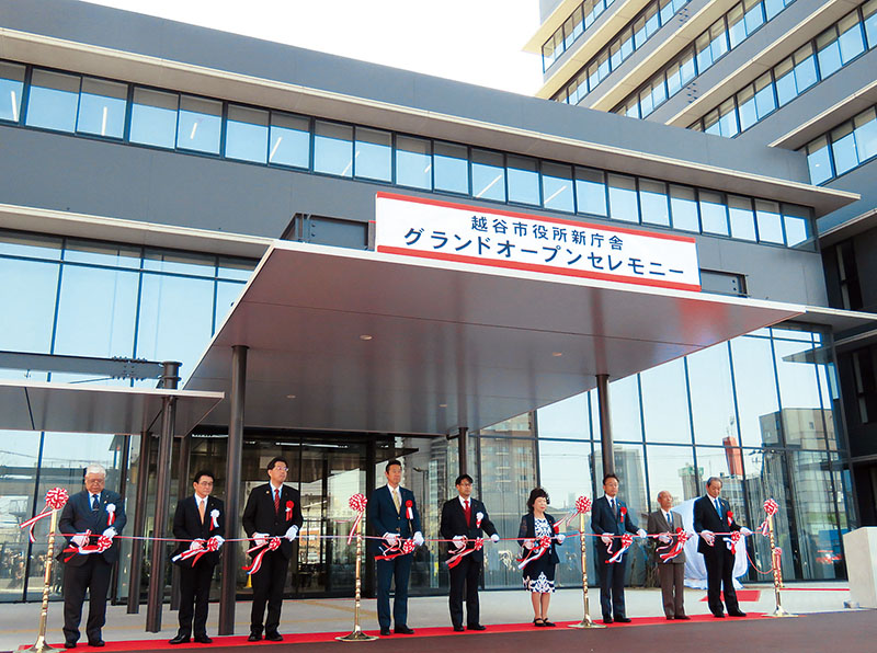 エントランス棟の前で行われたテープカット＝16日午前、越谷市役所