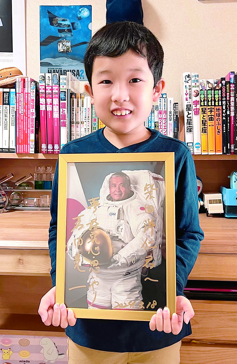 憧れの若田光一さんのサイン入り写真を持つ柴田洋仁さん。写真が自宅に届いてから額を用意した＝28日午前、埼玉県さいたま市南区