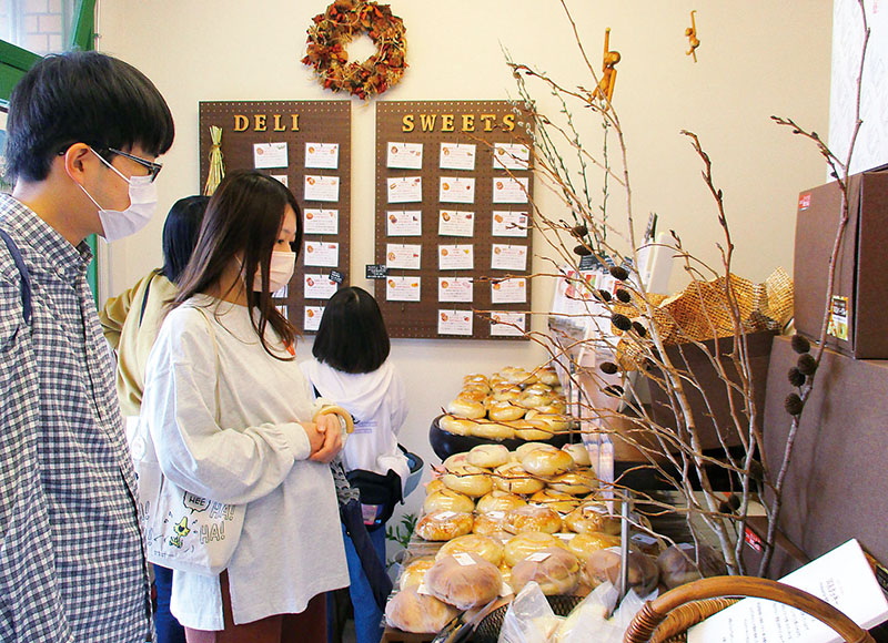 店頭に並ぶベーグルを選ぶ来店客。バーガーやサンドは注文を受けてから作る