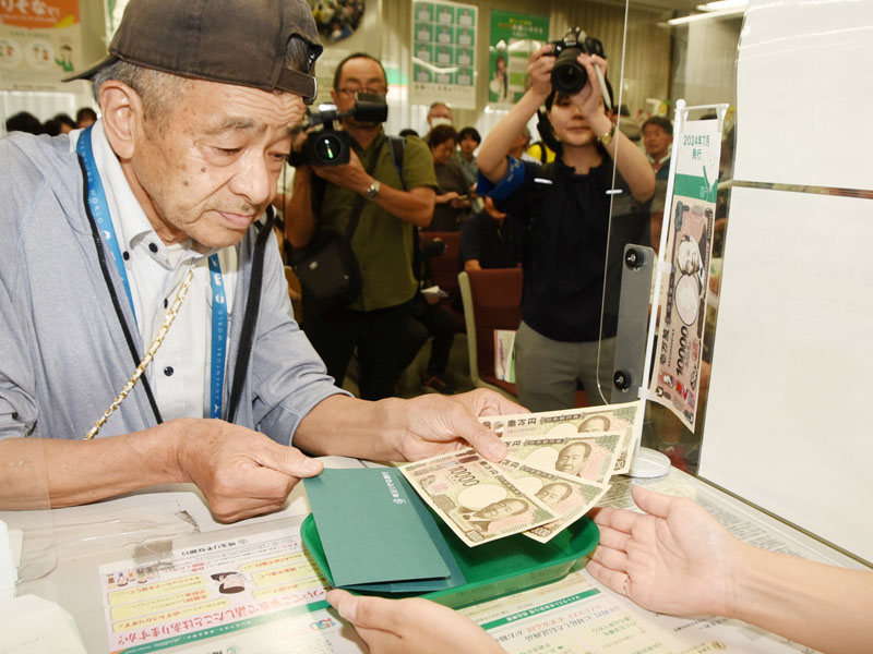 両替した新1万円札を受け取る来店客＝3日午後1時10分ごろ、深谷市西島町の埼玉りそな銀行深谷支店
