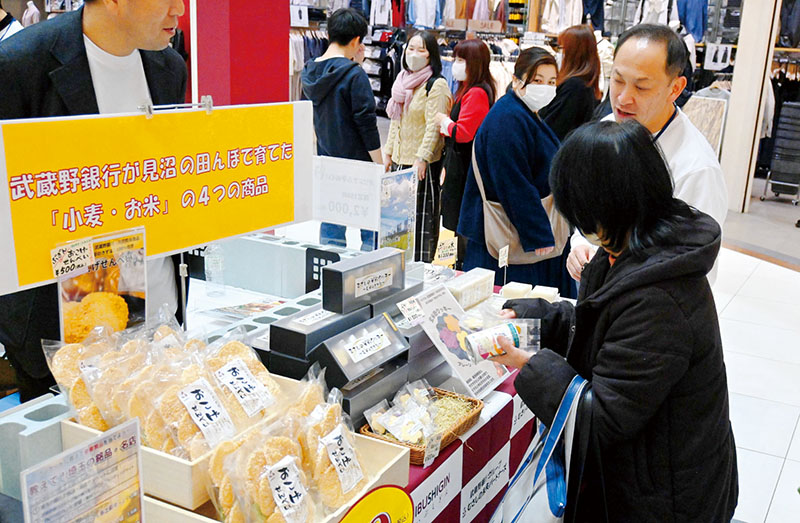 武蔵野銀行が育てたさいたま市産米・小麦を使って開発した商品を求める来場者＝15日、さいたま市緑区のイオンモール浦和美園