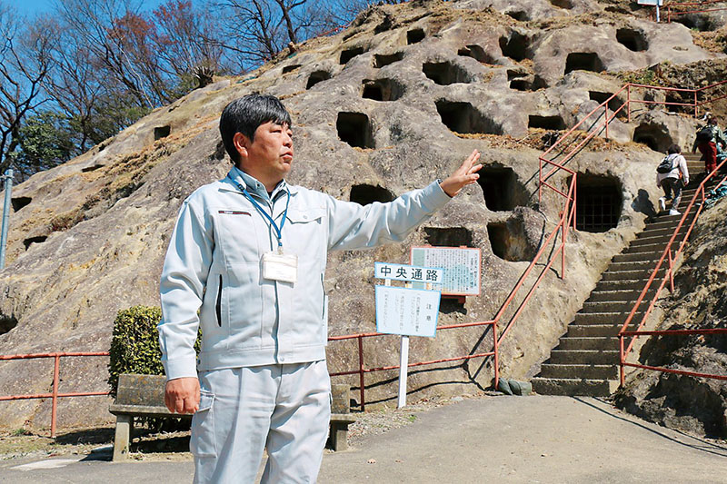 百穴の前で軍需工場の貴重さを語る学芸員の太田賢一さん