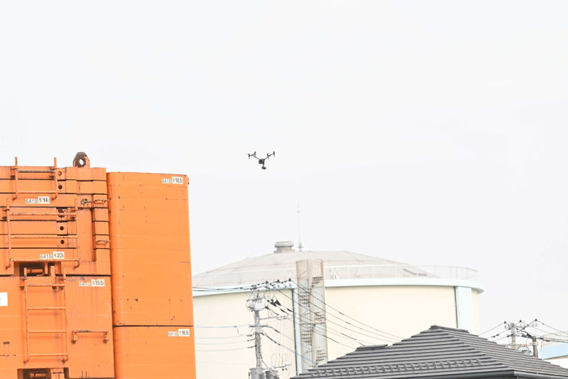 現場の状況を確認するドローン＝16日午前、八潮市中央