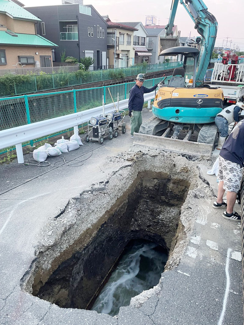 川口市の市道で発生した陥没。仮の下水管による仮復旧作業が行われていた＝29日午後7時ごろ、川口市南前川2丁目